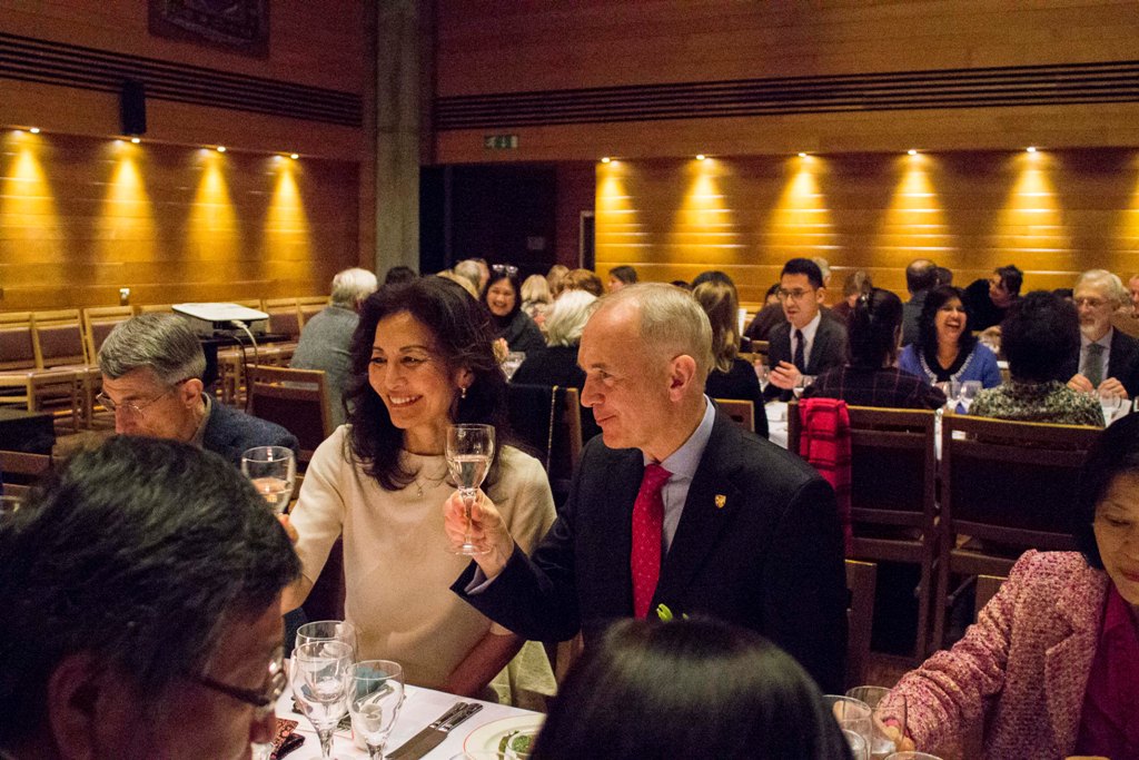 A diner raising a glass at Wolfson formal hall.